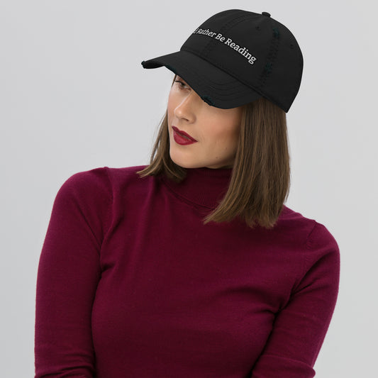 A black distressed hat with a faded, worn appearance, featuring the text 'I'd rather be reading' in a casual, playful font."